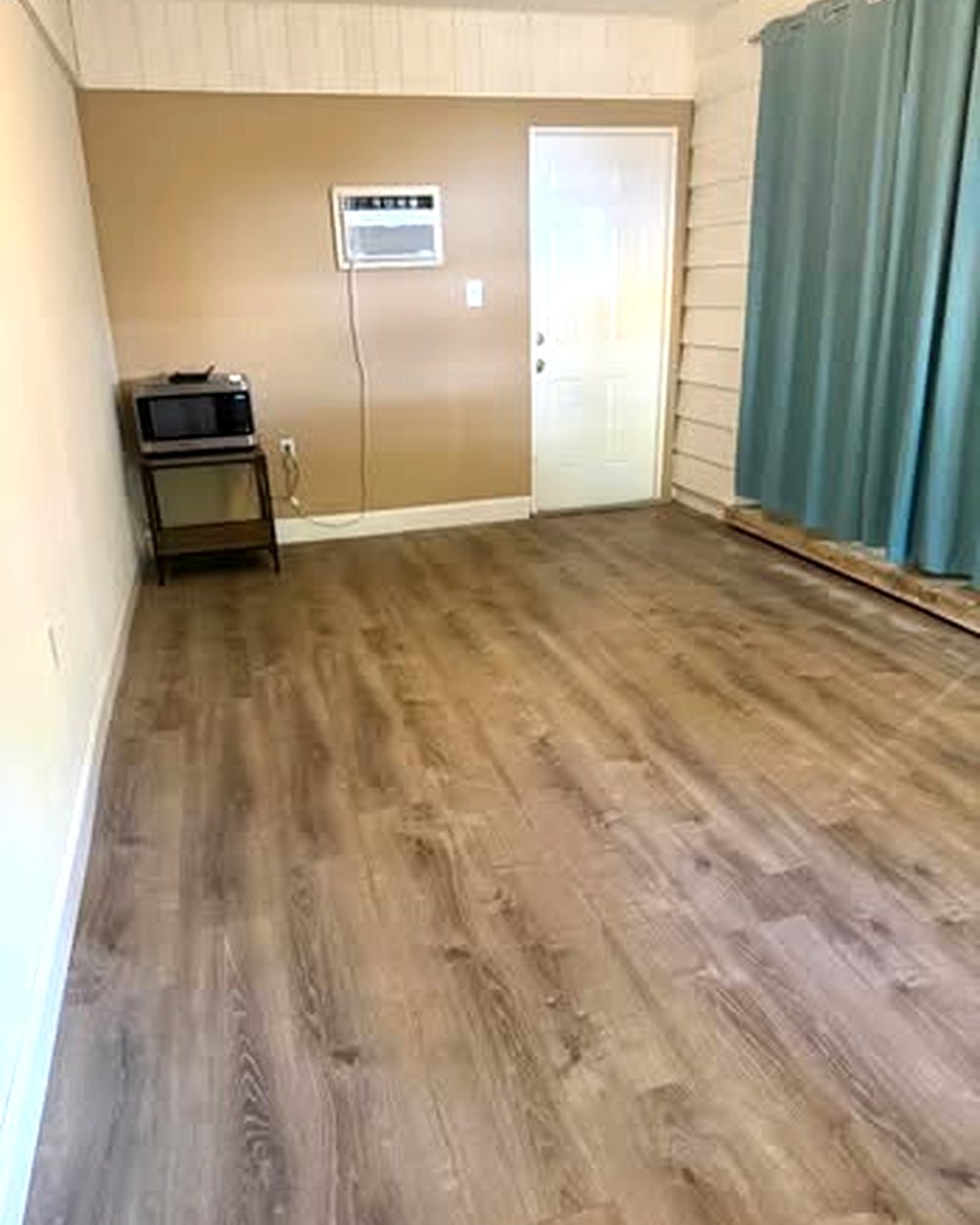 Bonus room with new vinyl plank flooring and a wall-mounted air conditioner