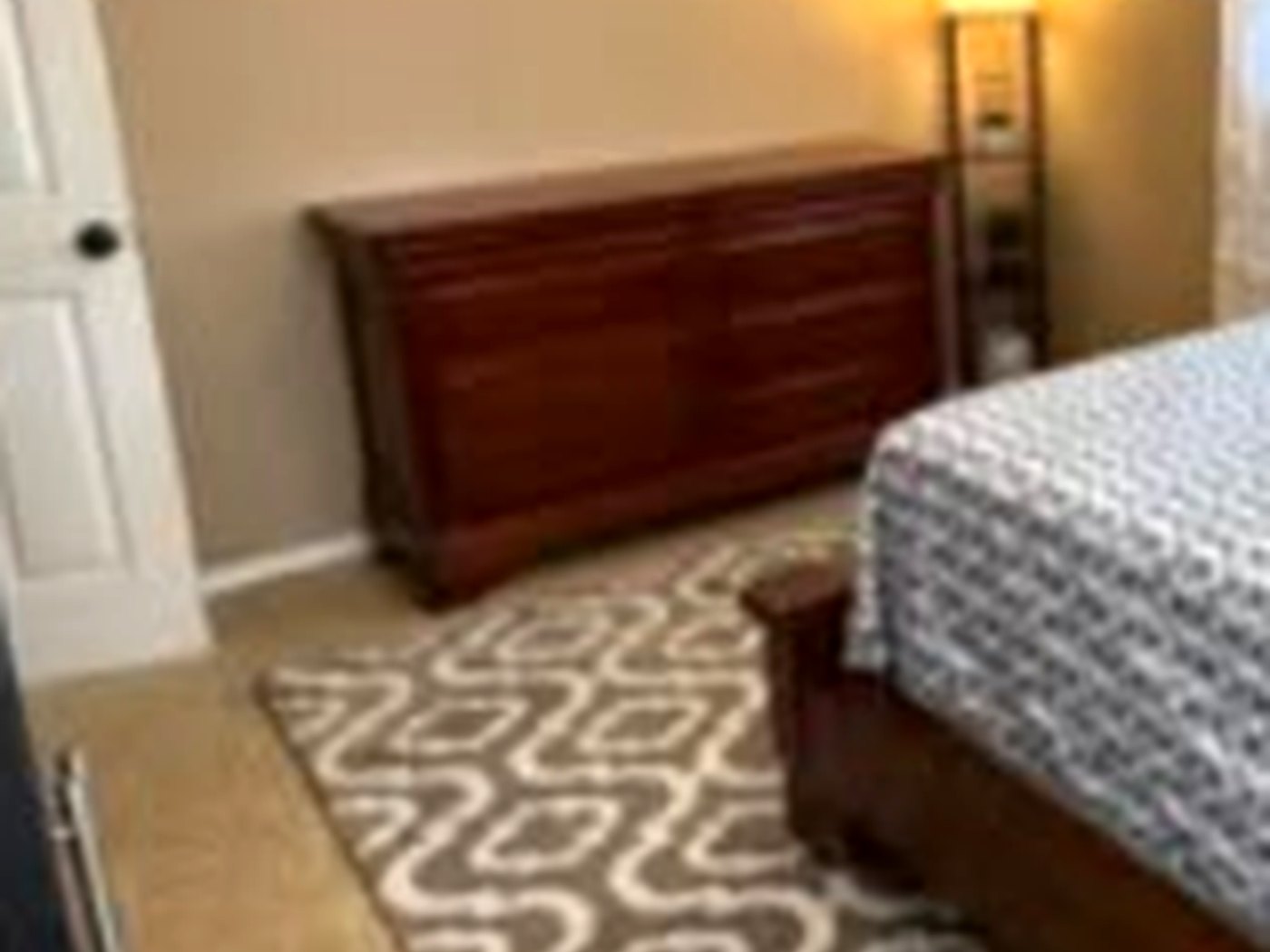 The original dark stained six-drawer dresser in the master bedroom