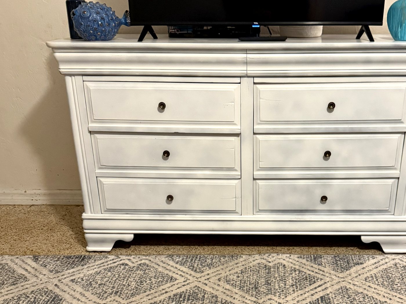 The same dresser sanded and refinished in white, now used as a TV stand