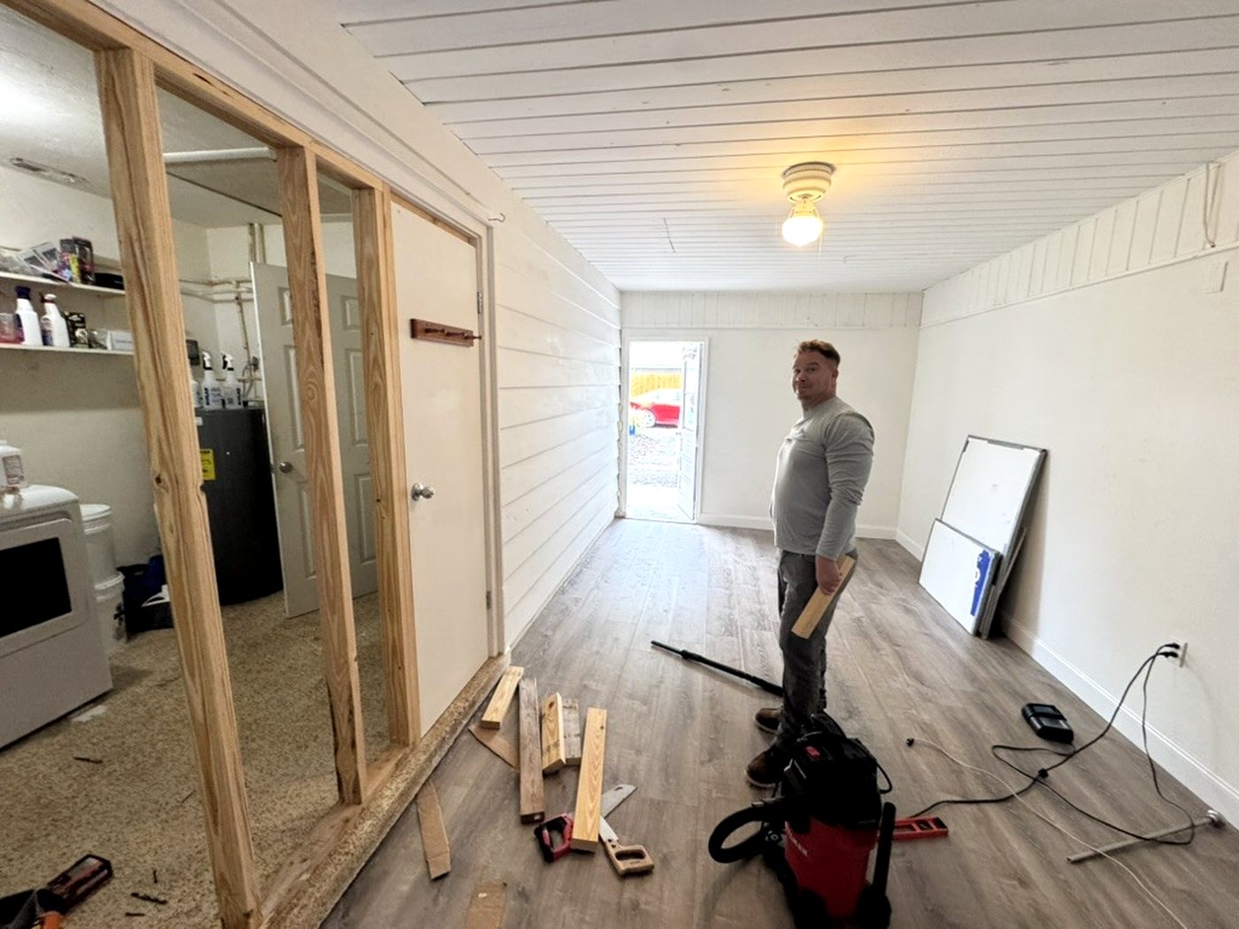 Wide view of the bonus room with the new stud wall and door opening framed out